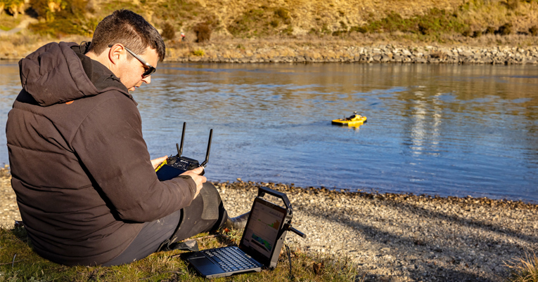 Environmental Technician Jono using a Surfbee to safely capture water data